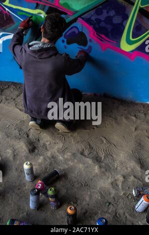 Pittore di graffiti sotto il ponte Siekierkowski, Varsavia, Polonia Foto Stock