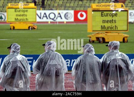 Lo Stadio Olimpico di Monaco di Baviera Germania 6.8.2002, Campionato Europeo di Atletica, funzionari di guardare un gare protetto dalla pioggia torrenziale dalla pioggia capes Foto Stock