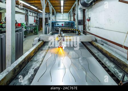 Tagliare il foglio di metallo sulla macchina di lavorazione. Plasma Taglio di metallo. Produzione di tubi metallici. Foto Stock