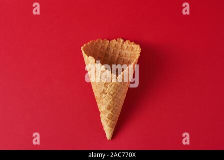 Vuoto cono gelato su sfondo rosso, top view flat laici. Stile minimalismo il concetto di creatività Foto Stock