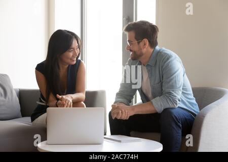 Diversi colleghi amici siedono in camera Ufficio avente conversazione informale Foto Stock