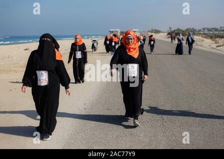 Le donne palestinesi prendere parte a una maratona che chiede di porre fine alla violenza contro le donne in Khan Yunis nel sud della striscia di Gaza. Foto Stock