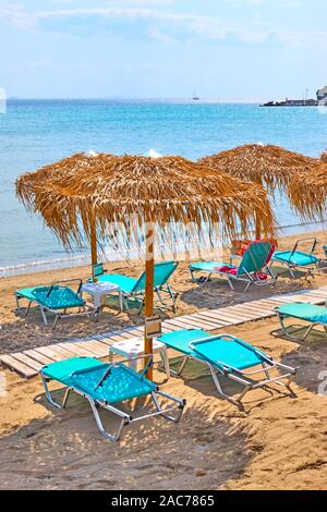 Spiaggia con ombrelloni di paglia dal mare sulla soleggiata giornata estiva Foto Stock