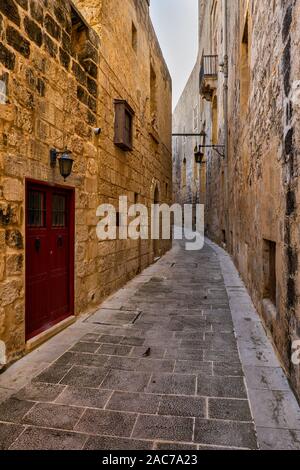 Città di Mdina a Malta, ombreggiata, strette strade lastricate e medievali e pareti di pietra case nella vecchia capitale. Foto Stock