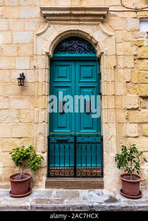 In legno porta verde in una entrata di pietra di Cospicua, Malta Foto Stock