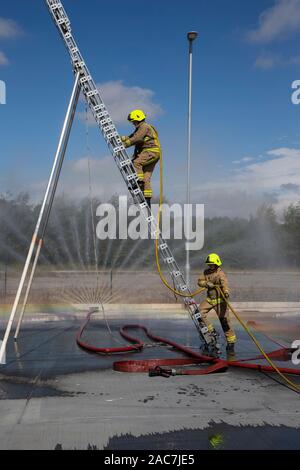 I vigili del fuoco in fase di una sessione di formazione utilizzando una scaletta in estensione completa nel West Yorkshire, Inghilterra, Regno Unito Foto Stock