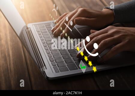 Imprenditrice premendo il pulsante in alto rating di qualità su laptop Foto Stock