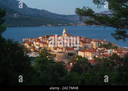 Vista di strade medievali e gli edifici del centro storico della città di Korcula di fronte all'isola di Peljesac dopo il tramonto,CROAZIA Foto Stock