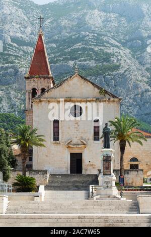 Scale sulla piazza di fronte alla chiesa parrocchiale di sv. Marko e la statua di Kačić Miošić davanti alla montagna Biokovo in Makarska, Croazia Foto Stock