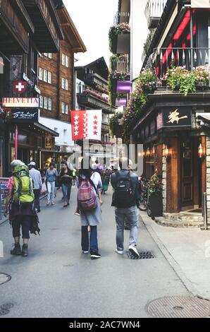 Zermatt, Svizzera - Luglio 10, 2019: Street con i turisti nel bellissimo villaggio alpino di Zermatt in estate. Il centro della città con le persone. Negozi, caffetterie e ristoranti. Foto Stock