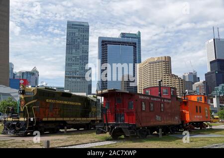 TORONTO, Canada - 06 16 2016: collezione di vecchi treni a Toronto Railway Museum di Roundhouse Park nel centro cittadino di Toronto con lo skyline della città in Foto Stock