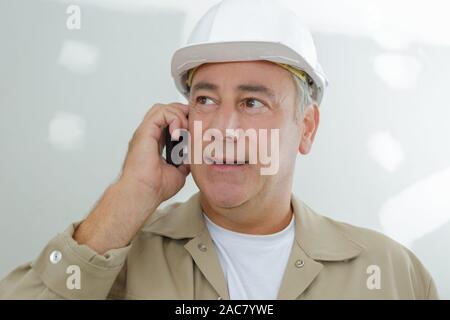 Una matura tradesman tramite telefono Foto Stock