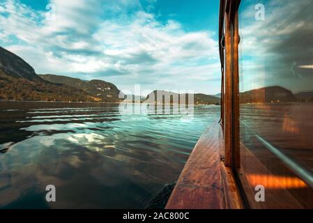 Barca a vela sul lago di Bohinj in estate, famosa meta di viaggio in Slovenia Il parco nazionale del Tricorno visto dalla barca elettrica Foto Stock