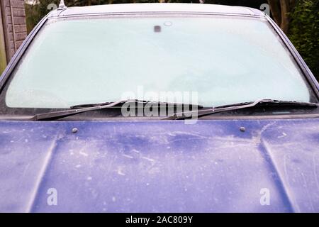 Parabrezza Parabrezza di auto blu automobile coperto di brina e ghiaccio in un freddo gelido inverno mattina Foto Stock