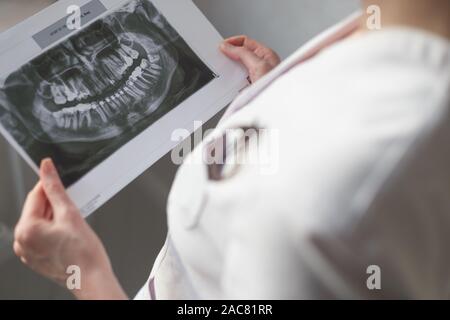 Dentista femmina guardando immagine a raggi x. Foto Stock