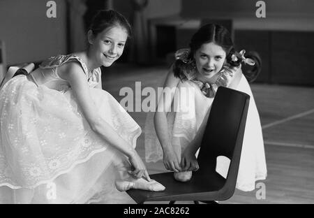 1980s, storico, 'IT's all in the Feet'...inside un balletto o scuola di danza, due giovani ragazze, ballerini, puntano alle loro dita, Inghilterra, Regno Unito. Le ragazze indossano una scarpa a punta, un tipo di scarpa indossata dai ballerini quando si allenano o si esibiscono, in quanto consentono ai ballerini di ballare sulle punte delle dita dei piedi per lunghi periodi di tempo. Foto Stock