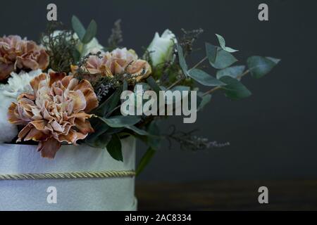 Una scatola con un bouquet vintage su uno sfondo scuro, il fuoco selettivo Foto Stock