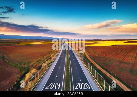 Vista aerea dell'autostrada sul tramonto. Sfondo di trasporto. Paesaggio con strada vicino a campi di campagna. Foto Stock