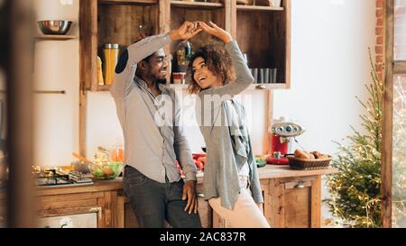 Giovane africano americano coppia danzante in cucina, spazio di copia Foto Stock