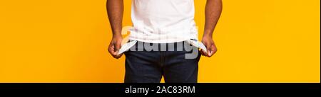 Disoccupati African American guy che mostra le tasche vuote Foto Stock