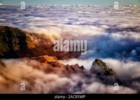 La natura dello sfondo con sunrise oltre le nuvole. È sulla cima del Pico do Arieiro mountain, l'isola di Madeira, Portogallo. Le montagne sono nascosti nella nebbia Foto Stock