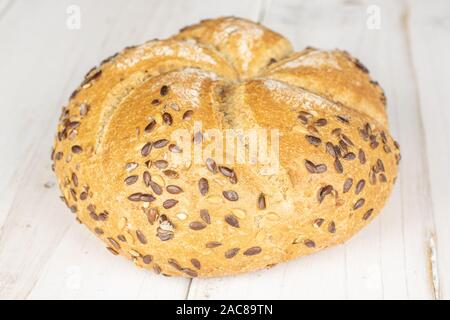 Un unico insieme di sesamo rotolo di kaiser in legno bianco Foto Stock