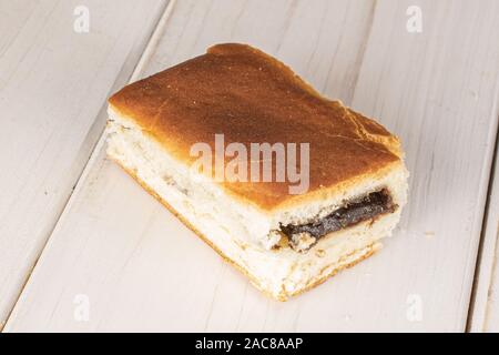 Un intero dolce di lievito bun ceca su legno bianco Foto Stock