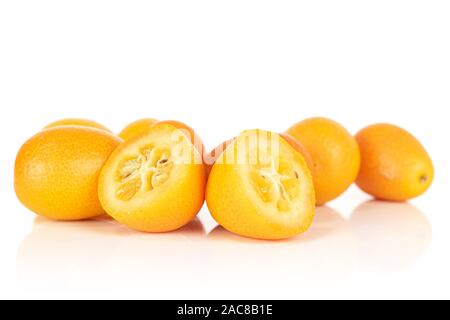 Gruppo di tre insieme due metà di gustoso orange kumquat isolati su sfondo bianco Foto Stock