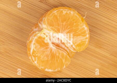Una metà della fresca purificata arancio mandarino flatlay su legno chiaro Foto Stock