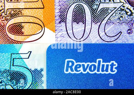 Foto macro dell'angolo della banca Revolut carta posizionata accanto a Sterling Pound banconote di diverse confessioni. Foto reale, non un montaggio. Foto Stock
