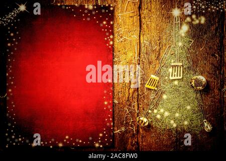 Background invitano a scrivere il menu di Natale. Vecchi utensili da cucina formando un albero di Natale e lo sbozzato carta rossa sul vecchio sfondo di legno. Foto Stock