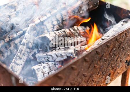 Fuoco nel braciere. Сhargrill con la combustione di legna. Preparare il carbone di legna prima di cuocere carne. Foto Stock