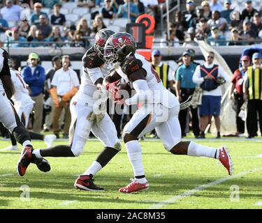 Jacksonville, Stati Uniti. 01 Dic, 2019. Bucanieri Quarterback Jameis Wilson (l) Hands off a marcia indietro Peyton Barbiere (25) per un breve periodo di guadagno durante il primo trimestre come il Tampa Bay Buccaneers play Jacksonville Jaguars presso la banca TIAA Campo a Jacksonville, in Florida, domenica 1 dicembre, 2019. I bucanieri sconfitto i giaguari da parte di un cliente di 28-11.Foto di Joe Marino/UPI Credito: UPI/Alamy Live News Foto Stock