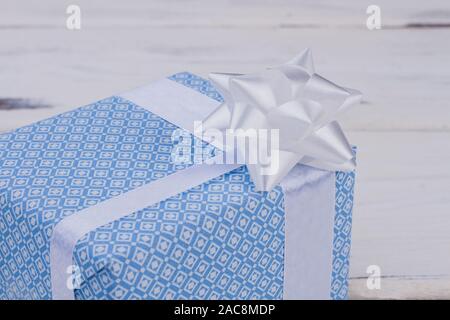 Confezione regalo con motivi blu e arco bianco. Foto Stock