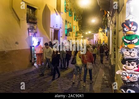 I visitatori di Calle La Ronda nel centro storico di Quito che si diverte in una serata calda. Calle La Ronda è la casa di numerosi artigiani e negozi. Foto Stock