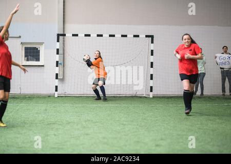 Giovani attiva sportive andando a buttare palla calcio ad un altro giocatore della sua squadra mentre in piedi di gates durante il gioco Foto Stock