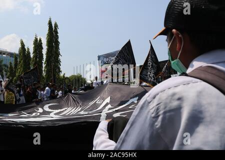 Makassar, Indonesia, 2° dic, 2019. Migliaia di musulmani portato islamica e bandiere Bandiere quando hanno difeso i profeti a Makassar, e ha chiesto alla polizia di perseguire gli autori del reato di diffamazione dell Islam. Due figure, ossia Sukmawati e Abu Janda sono considerati hanno molestato e diffamata musulmani. Credito: Herwin Bahar/Alamy Live News Foto Stock