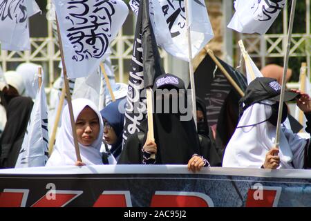 Makassar, Indonesia, 2° dic, 2019. Migliaia di musulmani portato islamica e bandiere Bandiere quando hanno difeso i profeti a Makassar, e ha chiesto alla polizia di perseguire gli autori del reato di diffamazione dell Islam. Due figure, ossia Sukmawati e Abu Janda sono considerati hanno molestato e diffamata musulmani. Credito: Herwin Bahar/Alamy Live News Foto Stock