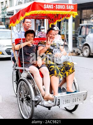 I turisti tenendo il cyclo Corsa in Rickshaw intorno a Hanoi Vietnam Foto Stock