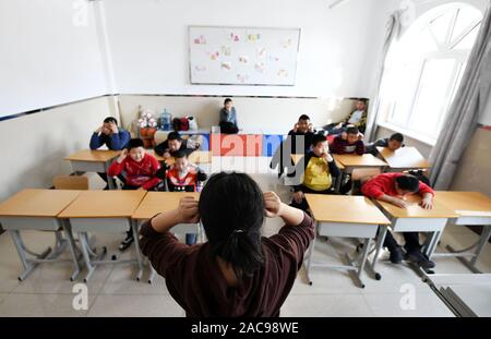 (191202) -- MUDANJIANG, Dicembre 2, 2019 (Xinhua) -- Zhang Na (anteriore) interagisce con gli studenti di una scuola di educazione speciale in Mudanjiang, a nord-est della Cina di Provincia di Heilongjiang, nov. 27, 2019. Zhang Na, 38, ha servito come un insegnante di musica in una scuola di educazione speciale per quindici anni. La maggior parte dei suoi studenti sono bambini con disabilità intellettuale. 'My gli studenti amano la musica e mostrano una grande sensibilità per la musica. Vorremmo riprodurre musica rilassante per aiutarli con le emozioni negative", ha detto. La scuola di educazione speciale, con una storia di oltre 60 anni, attualmente ha circa 100 studenti. (Xinhua/Wang Jia Foto Stock