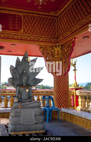 Scultura di Buddha nella posizione del loto sul trono con sette nagas. La scultura è grigio sotto il tetto con un ornamento dorato. Dorare il testo di sotto. Foto Stock