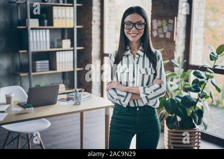 Foto di allegro positivo clever bella giovane imprenditore che aspirano a diventare ceo una giornata toothily sorridente con le mani piegate in pantaloni verdi Foto Stock