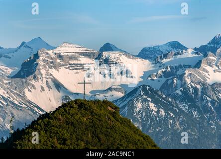 Vertice di croce am Martinskopf, vista da Herzogstand, montagne Karwendel sul retro, montagne coperte di neve, Baviera, Germania Foto Stock