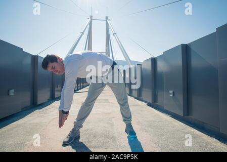 Un uomo sta facendo mattina allenamento sul ponte Foto Stock