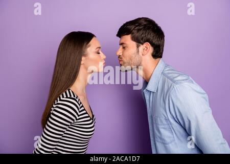 Foto del profilo di due persone giovane ragazzo lady in piedi di fronte gli occhi chiusi romanticismo momento kissing affettuoso usura elegante abito casual isolato Foto Stock