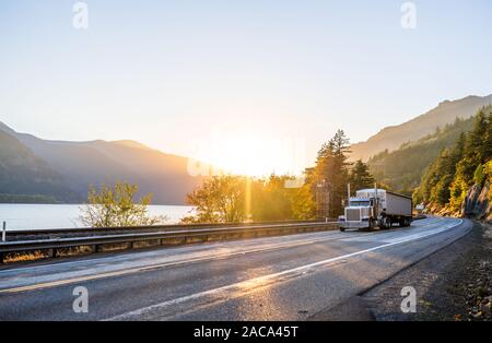 Big Rig potente classic long haul semi carrello il trasporto commerciale cargo in coperta lunga rinfusa semi rimorchio marcia su strada lungo il Columbia r Foto Stock