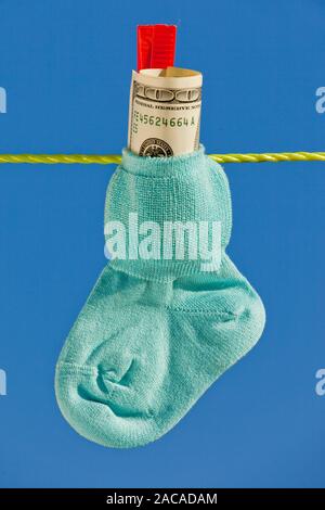 Baby calze su stendibiancheria con banconote di dollari Foto Stock