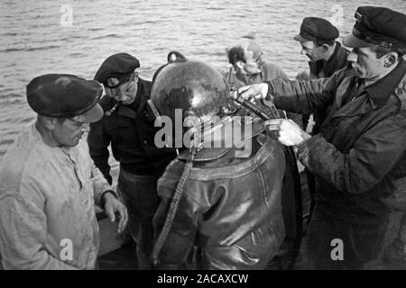 Schiffsarbeiter helfen Bojen Taucher in Taucheranzug, Emden, Niedersachsen, Deutschland, 1950. Nave lavoratori aiutare boe subacquei nella muta, Emden, Bassa Sassonia, Germania, 1950s. Foto Stock