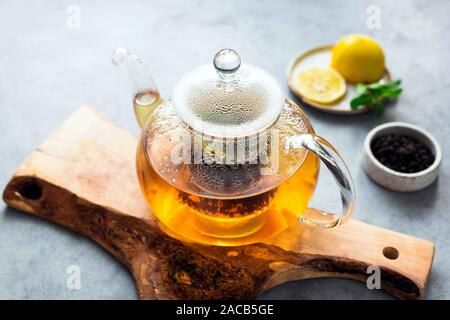 Il tè in vetro teiera con limone e menta. Fresco infuso di tè, tè alle erbe Foto Stock