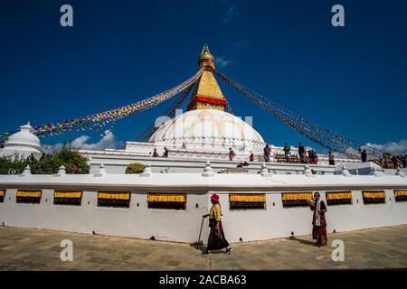 Vista panoramica di Boudha Stupa nel sobborgo Boudhanath, due donne locali che aleggia intorno ad esso Foto Stock